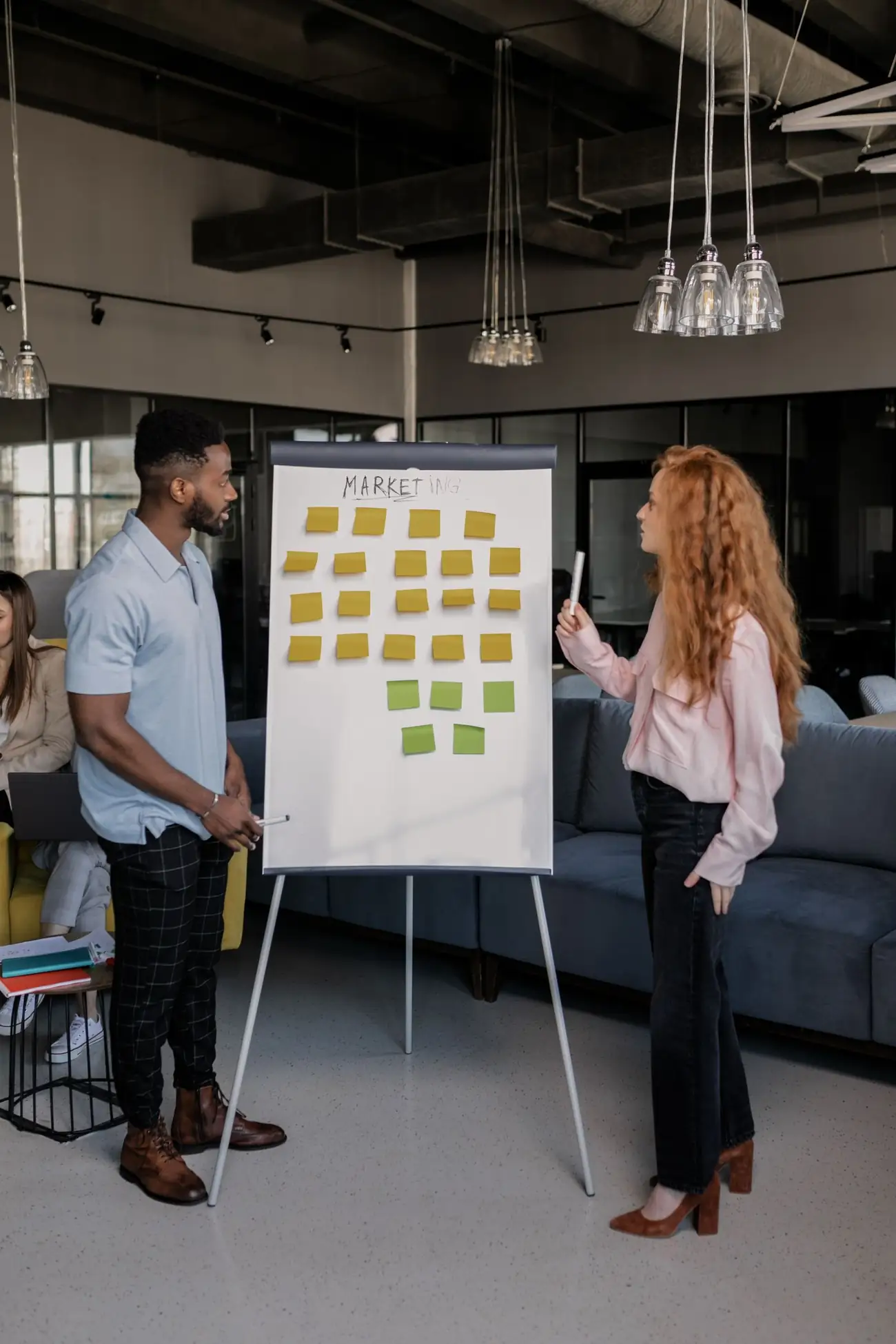 Two marketers planning strategy at a whiteboard
