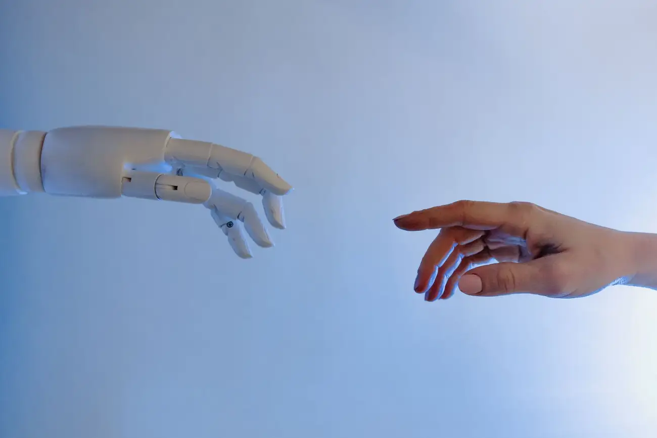 Human and robotic hands reaching toward each other